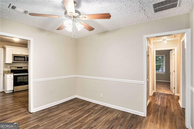 spare room with dark hardwood / wood-style floors, ceiling fan, and a textured ceiling