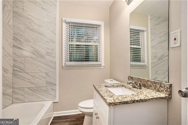 full bathroom featuring tiled shower / bath, toilet, vanity, and hardwood / wood-style flooring