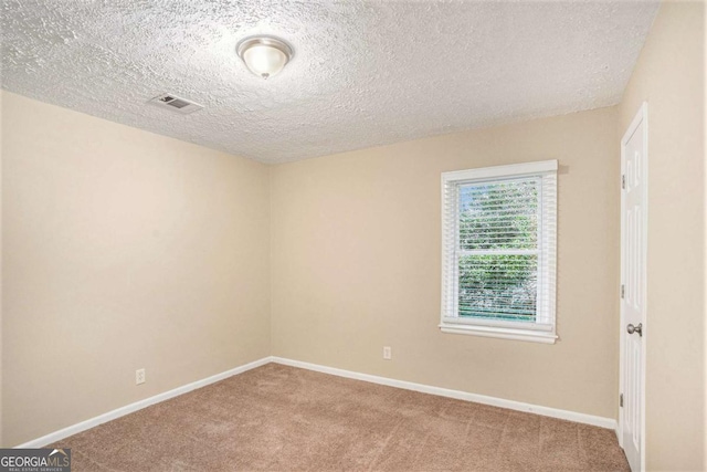 carpeted spare room with a textured ceiling