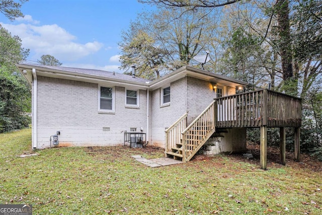 rear view of property with a yard and a wooden deck