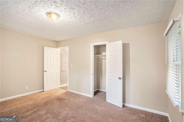 unfurnished bedroom featuring carpet flooring, a textured ceiling, and a closet