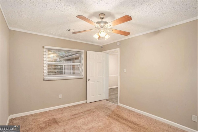 spare room with carpet flooring, a textured ceiling, ceiling fan, and crown molding