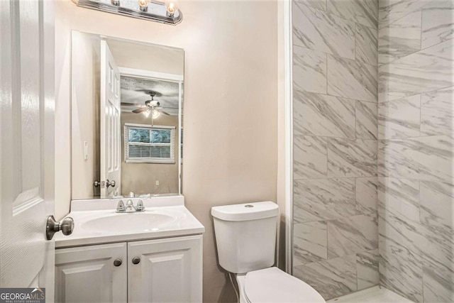 bathroom with tiled shower, ceiling fan, vanity, and toilet