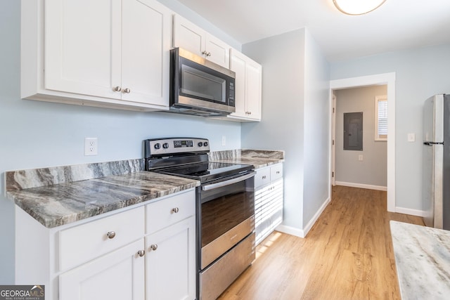 kitchen featuring white cabinetry, light stone counters, electric panel, appliances with stainless steel finishes, and light wood-type flooring