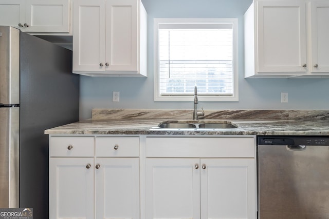 kitchen featuring stone countertops, white cabinetry, sink, and appliances with stainless steel finishes