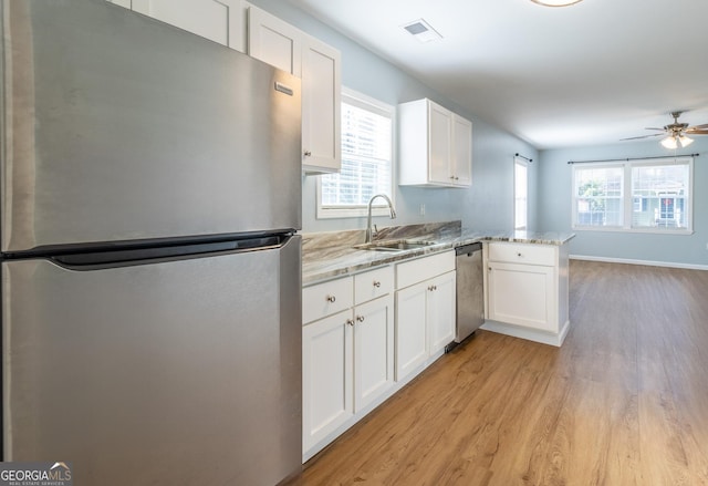 kitchen with white cabinetry, sink, kitchen peninsula, and stainless steel appliances