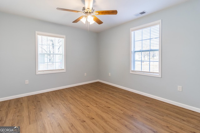 empty room featuring ceiling fan, light hardwood / wood-style floors, and a wealth of natural light