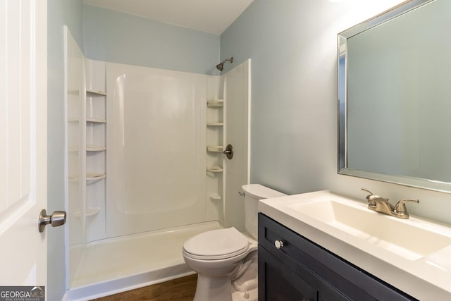 bathroom featuring hardwood / wood-style flooring, vanity, toilet, and walk in shower