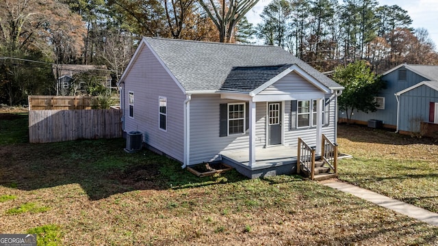 bungalow with cooling unit and a front lawn