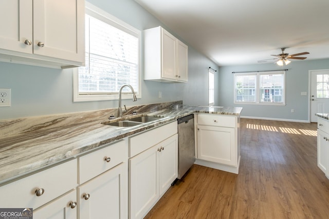 kitchen with dishwasher, sink, light hardwood / wood-style flooring, kitchen peninsula, and white cabinets