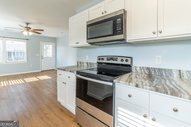 kitchen with light stone countertops, appliances with stainless steel finishes, ceiling fan, light hardwood / wood-style flooring, and white cabinets