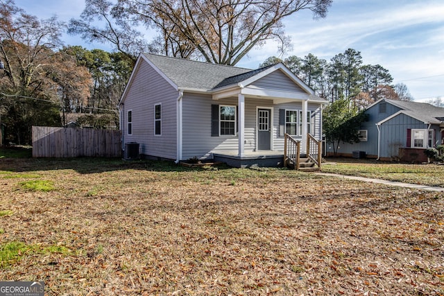 bungalow-style house with central AC unit, a porch, and a front lawn