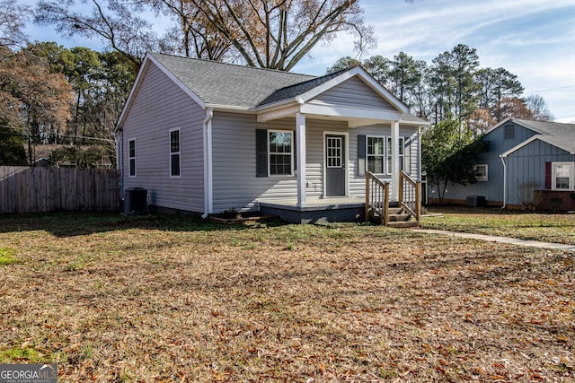 bungalow-style home featuring a front yard, central AC, and covered porch