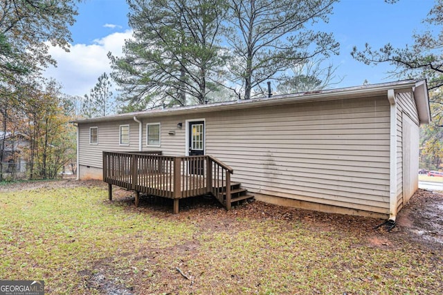 rear view of property featuring a lawn and a deck