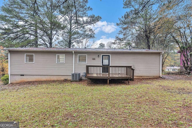 back of house featuring central AC, a lawn, and a wooden deck