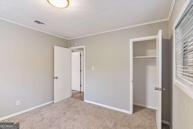 unfurnished bedroom with crown molding, a closet, carpet floors, and a textured ceiling