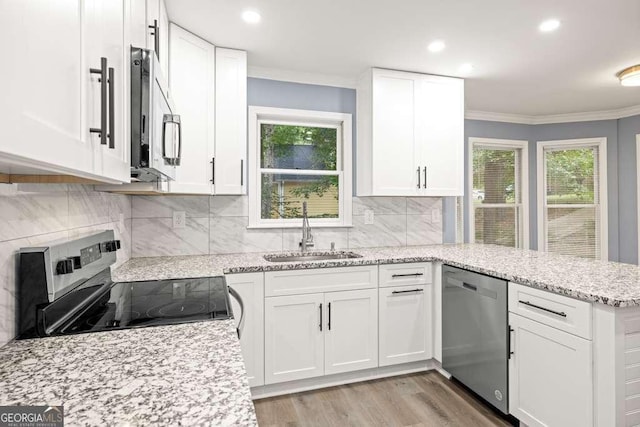 kitchen with a healthy amount of sunlight, white cabinetry, sink, and appliances with stainless steel finishes