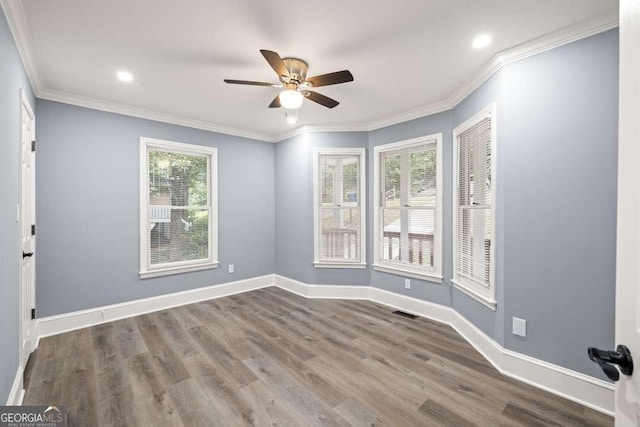 unfurnished room with wood-type flooring, a wealth of natural light, ornamental molding, and ceiling fan