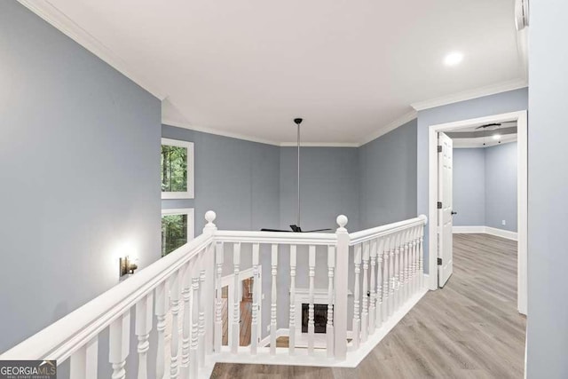 hallway featuring crown molding and light hardwood / wood-style flooring