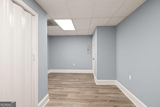 basement with hardwood / wood-style flooring and a drop ceiling