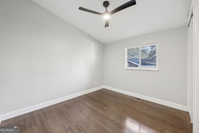 empty room featuring vaulted ceiling, ceiling fan, and dark wood-type flooring