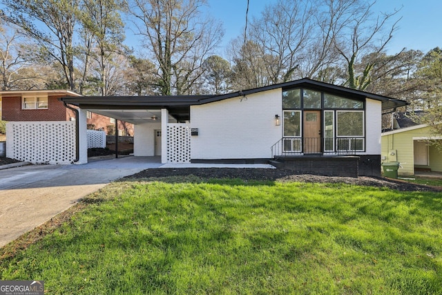 view of front of property with a front yard and a carport