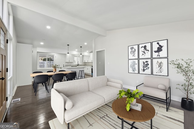 living room featuring vaulted ceiling with beams, hardwood / wood-style flooring, and sink