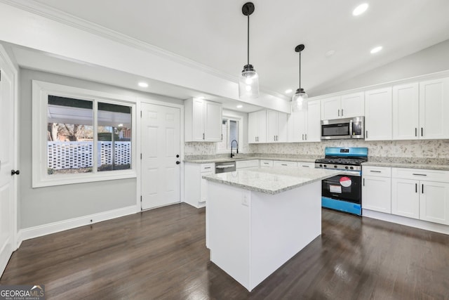 kitchen featuring white cabinetry, hanging light fixtures, and appliances with stainless steel finishes