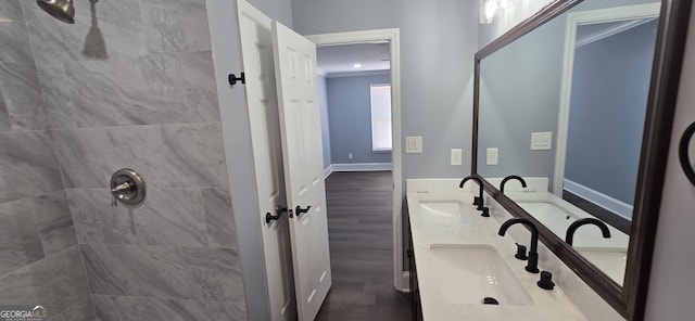 bathroom featuring a tile shower, vanity, hardwood / wood-style flooring, and crown molding