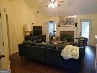 living room featuring ceiling fan, dark hardwood / wood-style flooring, and vaulted ceiling