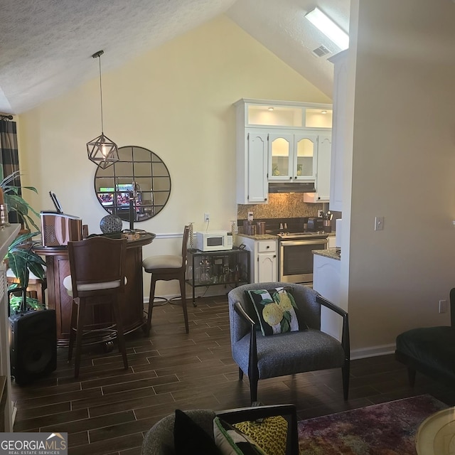 living room featuring dark hardwood / wood-style floors, a textured ceiling, and high vaulted ceiling