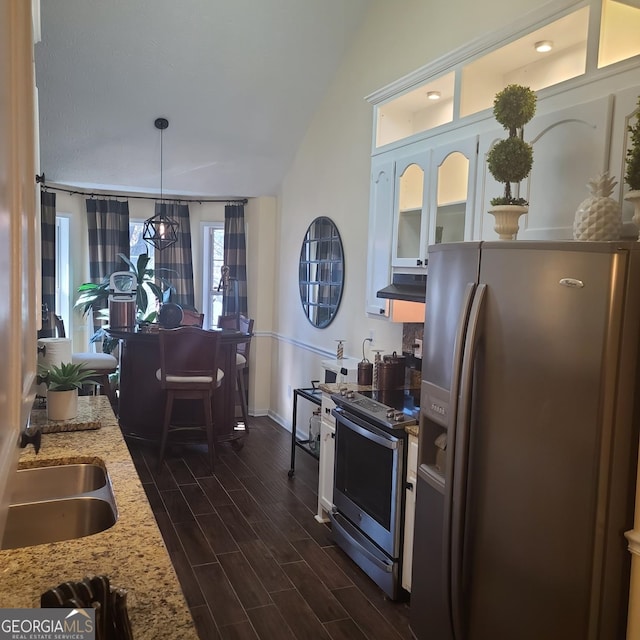 kitchen with sink, dark hardwood / wood-style floors, light stone countertops, appliances with stainless steel finishes, and decorative light fixtures