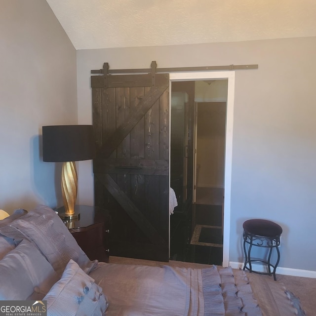 carpeted bedroom with a barn door, a closet, and lofted ceiling