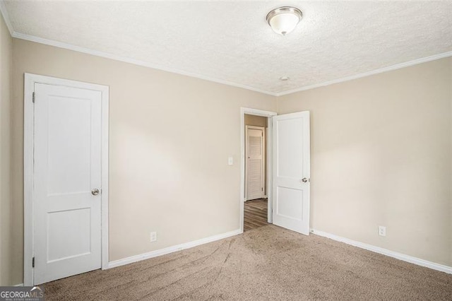 empty room featuring crown molding, carpet floors, and a textured ceiling