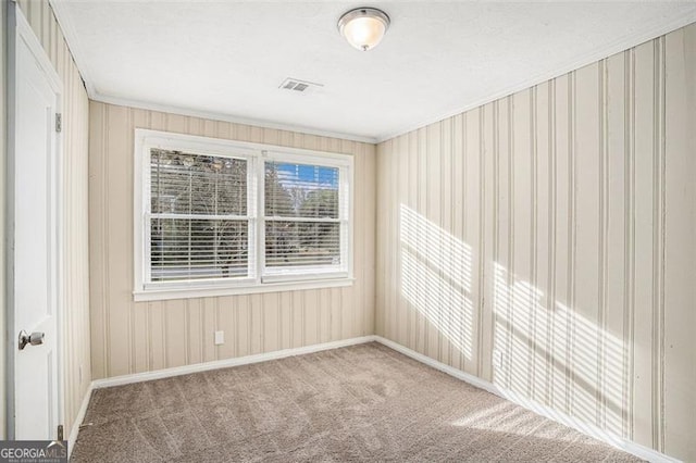 carpeted empty room featuring crown molding