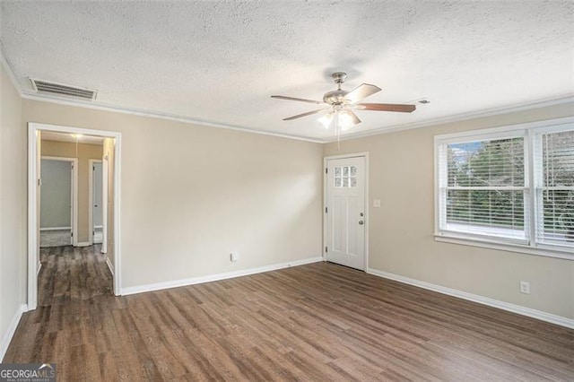 unfurnished room with crown molding, ceiling fan, dark wood-type flooring, and a textured ceiling