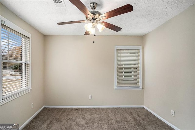 unfurnished room featuring carpet and a textured ceiling