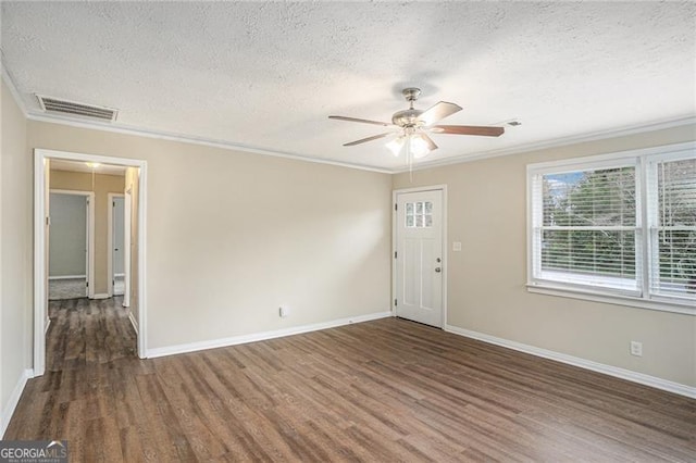 spare room with ceiling fan, dark wood-type flooring, a textured ceiling, and ornamental molding