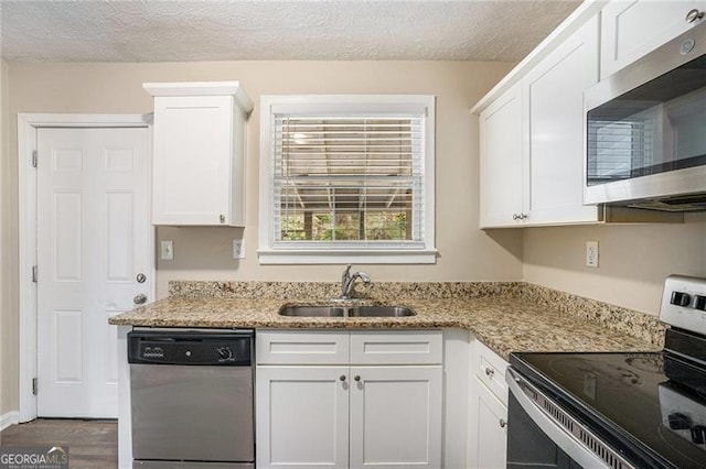 kitchen featuring light stone countertops, appliances with stainless steel finishes, dark hardwood / wood-style flooring, sink, and white cabinets