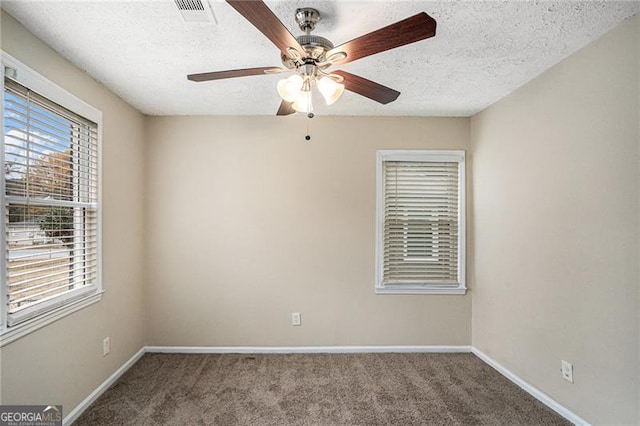 carpeted spare room with ceiling fan and a textured ceiling