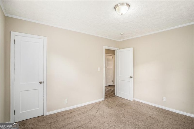 carpeted empty room with a textured ceiling and ornamental molding