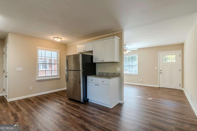 kitchen featuring white cabinets, stainless steel fridge, and a wealth of natural light