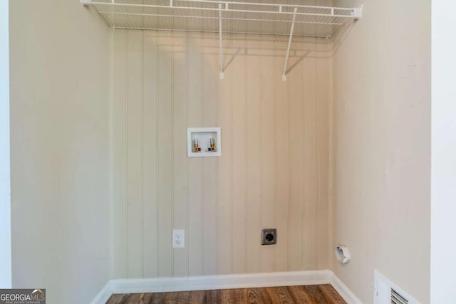 laundry room with hookup for an electric dryer, washer hookup, dark wood-type flooring, and wood walls