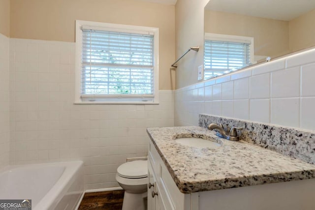 bathroom featuring a washtub, vanity, wood-type flooring, and tile walls