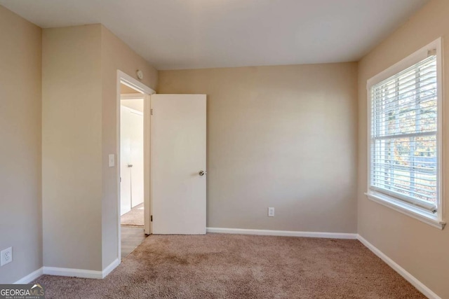 unfurnished room featuring light colored carpet and a wealth of natural light