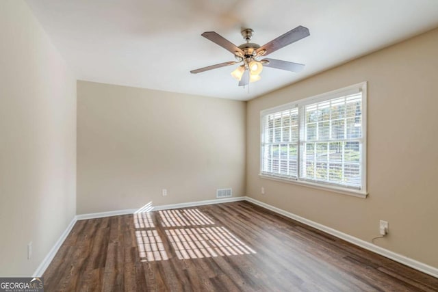 spare room with dark hardwood / wood-style floors and ceiling fan