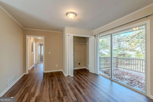 unfurnished bedroom featuring access to exterior, a closet, dark hardwood / wood-style floors, and ornamental molding