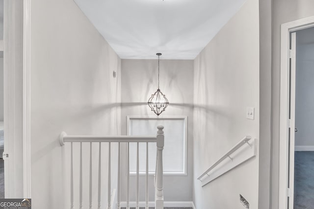 stairs with carpet flooring and an inviting chandelier