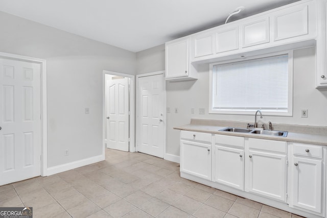 kitchen featuring white cabinets, light tile patterned floors, and sink