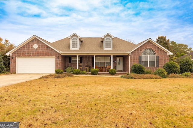 view of front facade with covered porch, a garage, and a front lawn